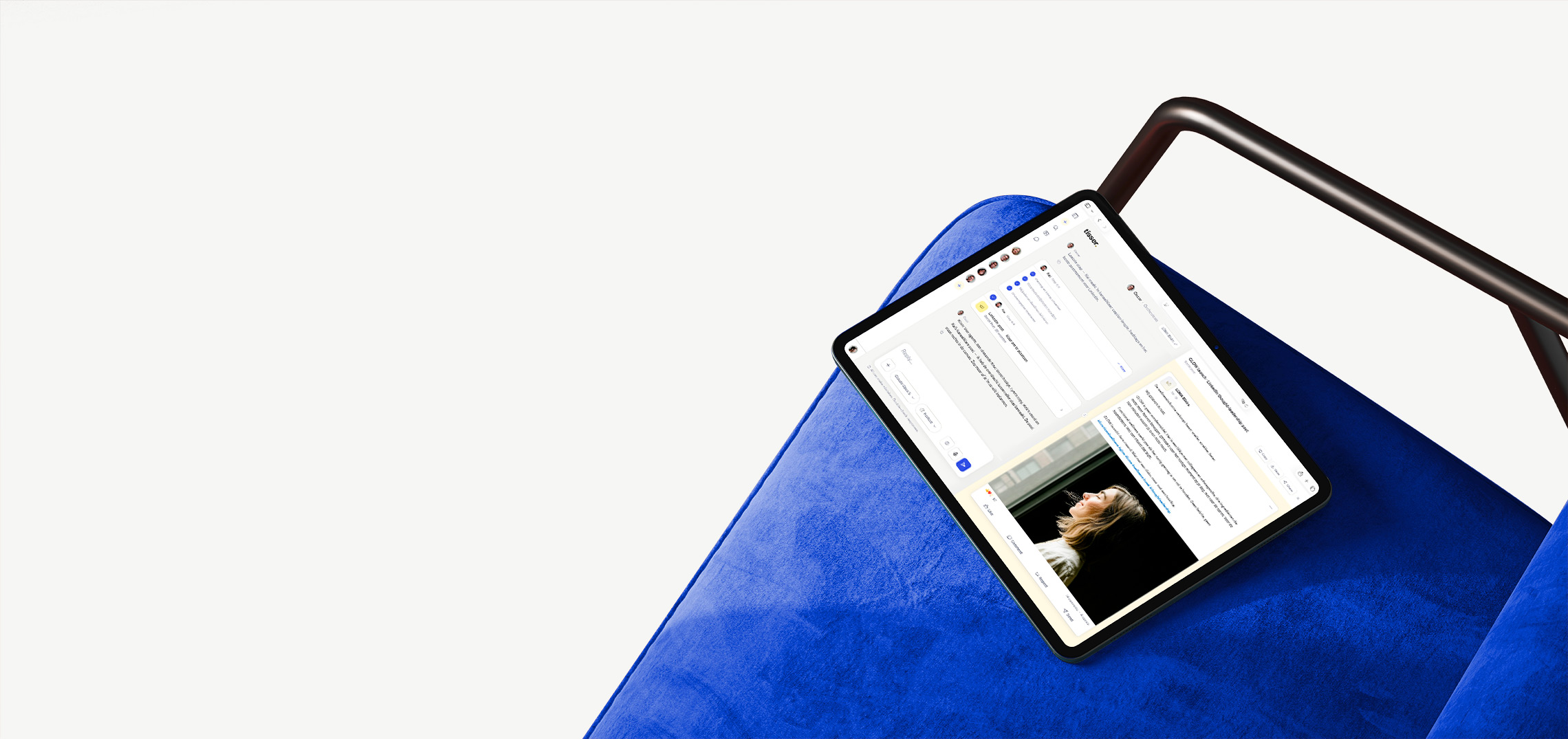 Tisser on a tablet, resting on a cobalt velvet chair